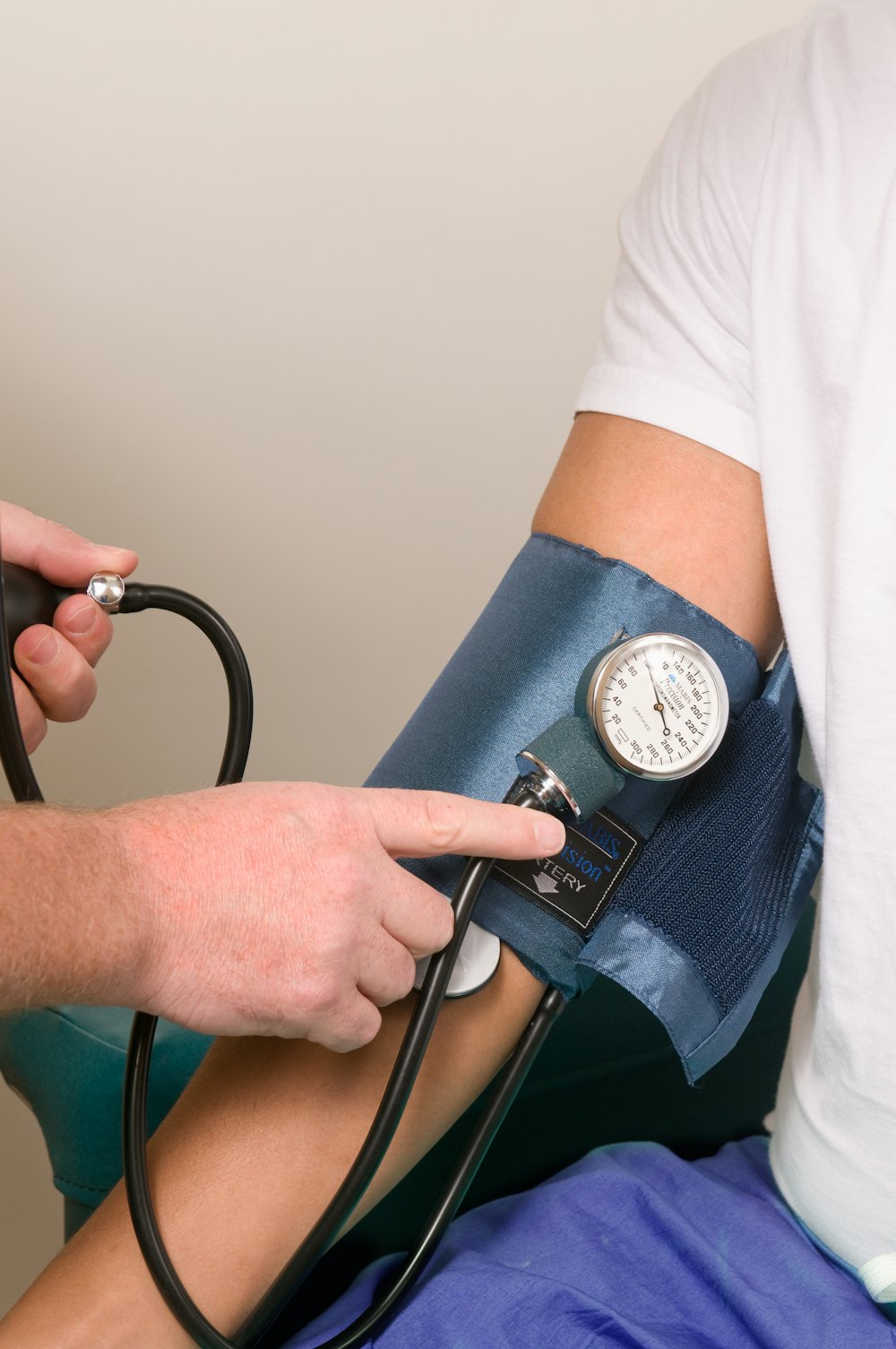 A clinician wrapping a blood pressure cuff around a patient's arm